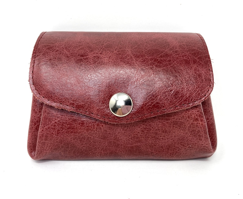 May include: A burgundy leather coin purse with a silver snap closure.