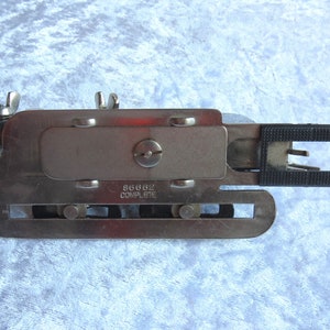 May include: A silver metal sewing machine foot with a black plastic piece and the text "86662 COMPLETE" on the side.