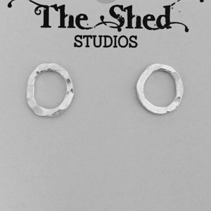 May include: A pair of silver hammered circle earrings. The earrings are simple and modern, and would make a great gift.