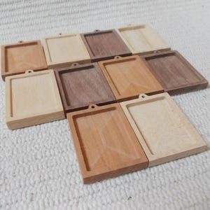 Puede incluir: Un conjunto de 10 marcos de fotos de madera en una variedad de tonos de madera, incluyendo marrón claro y marrón oscuro. Los marcos son todos rectangulares y tienen un diseño simple. Son perfectos para mostrar fotos, obras de arte u otros artículos pequeños.