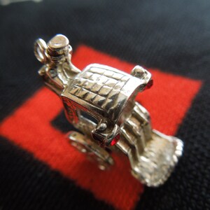 May include: Silver charm of a horse-drawn carriage with a detailed design. The carriage is facing forward with the driver's seat visible. The charm is a detailed piece of jewelry.