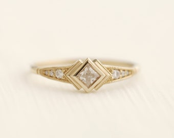 May include: A gold ring with a square-shaped diamond in the center and smaller diamonds on the band.