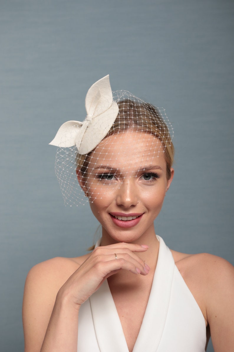 Bridal small ivory hat with bow and birdcage, creamy white fascinator with netting, felt creamy white headpiece with veiling 