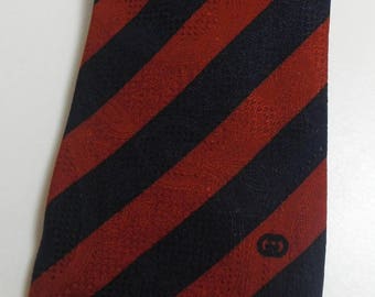 May include: A red and black striped tie with a small logo in the lower right corner.