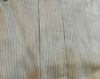 May include: Close-up of a light grey and black striped fabric with a vertical seam down the centre.