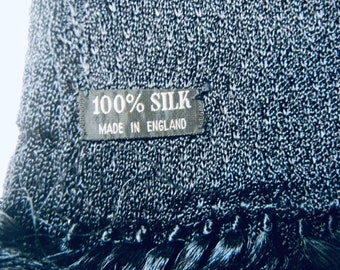 May include: A black silk scarf with a black label that reads "100% SILK MADE IN ENGLAND".