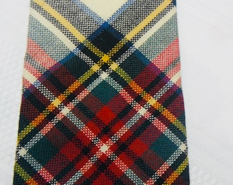 May include: A red, white, blue, green, and yellow plaid tie. The tie has a diamond pattern in the center.