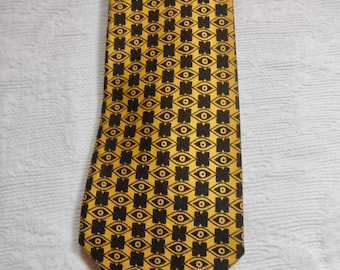 May include: A yellow silk tie with a black eye pattern.