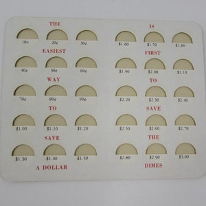 May include: A white card with a grid of 24 circles, each with a different amount of money written inside. The circles are arranged in rows and columns. The text "THE EASIEST WAY TO SAVE THE DIMES" is written in red letters on the card.