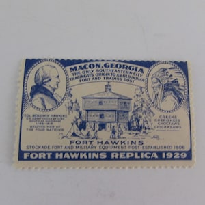 May include: A blue and white vintage postcard depicting Fort Hawkins, a stockade fort and military equipment post established in 1806 in Macon, Georgia. The postcard features a drawing of the fort, a portrait of Col. Benjamin Hawkins, and a portrait of a Native American. The text on the postcard reads "Fort Hawkins Replica 1929".