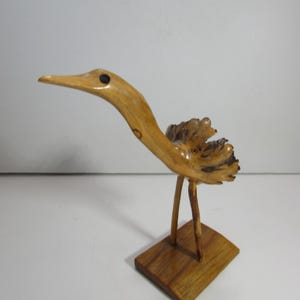 May include: A white ceramic mug with a black handle and the text "But First, Coffee" in a bold, black font. The mug is set against a neutral background, highlighting its simple design.