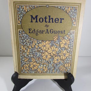 May include: A vintage book titled "Mother" by Edgar A. Guest. The cover features a floral design with yellow flowers and green leaves on a beige background.