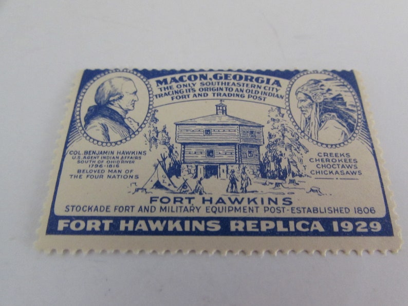 May include: A blue and white vintage postcard depicting Fort Hawkins in Macon, Georgia. The postcard features a drawing of the fort, a portrait of Col. Benjamin Hawkins, and a portrait of a Native American. The text on the postcard reads "Macon, Georgia, The Only Southeastern City Tracing Its Origin To An Old Indian Fort And Trading Post", "Fort Hawkins, Stockade Fort And Military Equipment Post-Established 1806", and "Fort Hawkins Replica 1929".