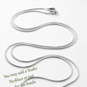 May include: A 1mm .925 sterling silver snake necklace with a lobster claw clasp. The text at the top reads "SNAKE NECKLACE 1MM - .925 STERLING SILVER" and the text at the bottom reads "You may add a Snake Necklace or just order the beads."