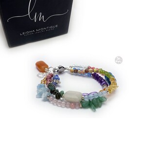 Multi-strand bracelet featuring a variety of colorful gemstones, including amethyst, rose quartz, aquamarine, and citrine. The bracelet has a silver clasp and a heart charm.