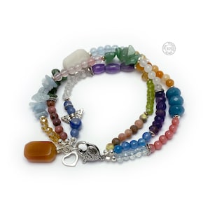 Multi-strand bracelet featuring a variety of colorful gemstones, including amethyst, rose quartz, aquamarine, and citrine. The bracelet has a silver clasp and a heart charm.