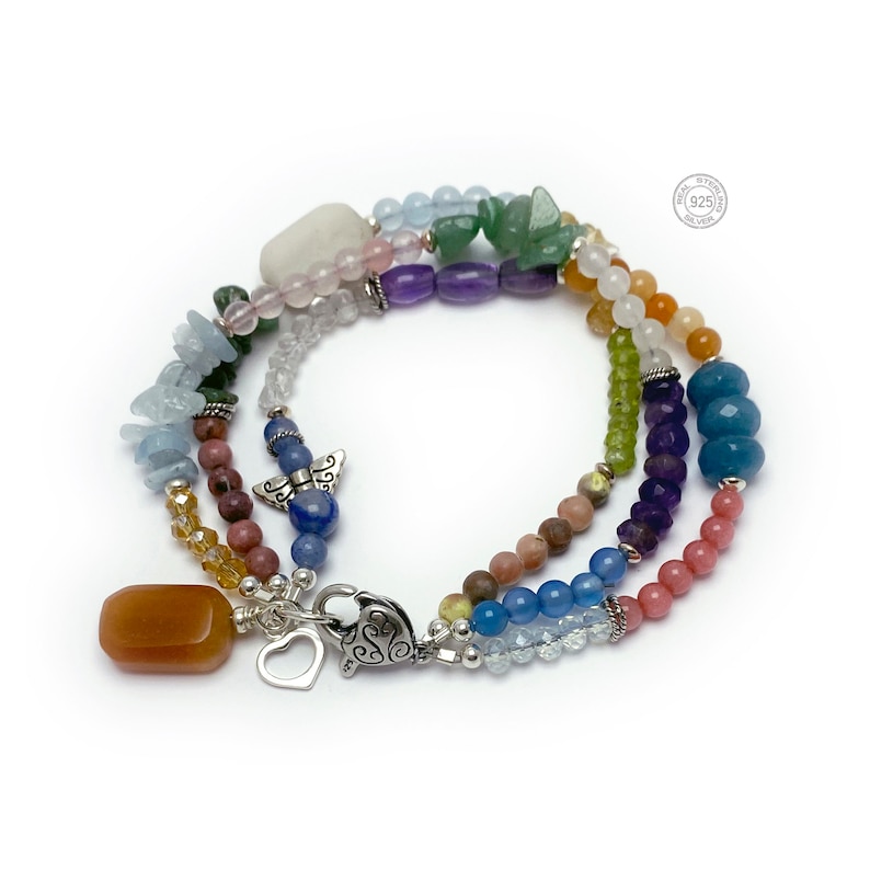 Multi-strand bracelet featuring a variety of colorful gemstones, including amethyst, rose quartz, aquamarine, and citrine. The bracelet has a silver clasp and a heart charm.