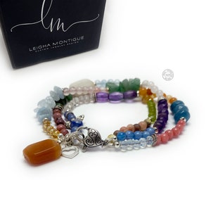 Multi-strand bracelet featuring a variety of colorful gemstones, including amethyst, rose quartz, aquamarine, and citrine. The bracelet has a silver clasp and a heart charm.