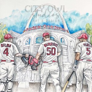 May include: Watercolor painting of three baseball players wearing red and white uniforms with their numbers on the back. The players are standing in front of Busch Stadium in St. Louis, Missouri. The stadium's iconic arch is visible in the background.