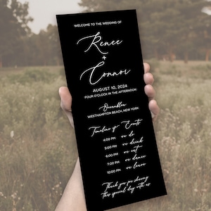 May include: A tall, rectangular black wedding program card with white text. It reads: Welcome to the wedding of Renee + Connor, August 10, 2024, four o'clock in the afternoon, Oceanbleu, Westhampton Beach, New York, and a timeline of events.