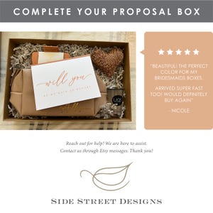 May include: A proposal box with a beige cosmetic bag, a card that says "will you be my maid of honor", a knitted heart, and a small candle. The box also contains decorative filler and the text "COMPLETE YOUR PROPOSAL BOX".