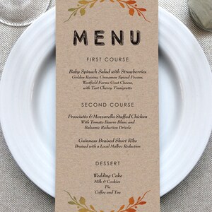 May include: A brown paper menu with a fall-themed border. The menu lists the courses for a meal: First Course: Baby Spinach Salad with Strawberries, Golden Raisins, Cinnamon Spiced Pecans, Westfield Farms Goat Cheese, with Tart Cherry Vinaigrette. Second Course: Prosciutto & Mozzarella Stuffed Chicken with Tomato Beurre Blanc and Balsamic Reduction Drizzle. Guinness Braised Short Ribs Braised with a Local Malbec Reduction. Dessert: Wedding Cake, Milk & Cookies, Pie, Coffee and Tea.