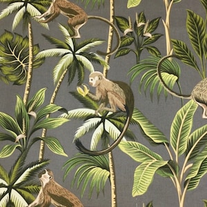 May include: A grey fabric with a repeating pattern of monkeys and palm trees. The monkeys are brown and white and are holding bananas. The palm trees are green and have brown trunks.