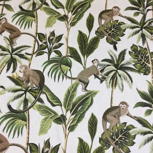 May include: A white fabric with a repeating pattern of green palm trees and monkeys. The monkeys are brown and have long tails. The palm trees have green fronds and brown trunks.