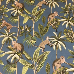 May include: A blue fabric with a repeating pattern of monkeys and palm trees. The monkeys are brown and the palm trees have green leaves and brown trunks.
