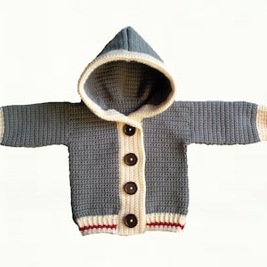 May include: A gray hooded cardigan with white and red trim. The cardigan has a button closure and is crocheted.