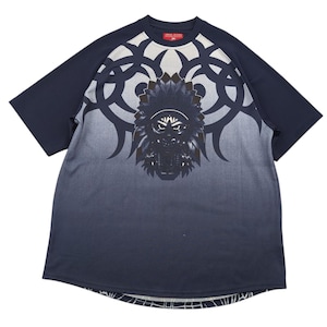 May include: Navy blue t-shirt with a tribal design featuring a Native American chief graphic. The shirt has a gradient effect, transitioning from navy to gray. The sleeves are solid navy, and the shirt has the text "Cross Jeans" on the top.