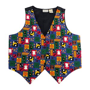 Puede incluir: Un chaleco azul con temática de Halloween. El chaleco está cubierto con un patrón de patchwork de calabazas, fantasmas, murciélagos y maíz dulce. El chaleco tiene un forro negro y un cuello en V.