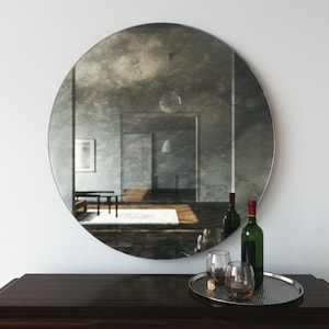 Antiqued round mirror. Decorative wall mirror that casts an interesting, cloudy reflection of room. Round mirror with European chic design.