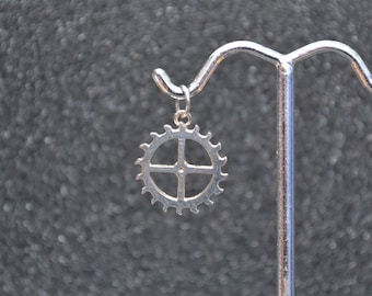 Cast Escape Gear Pendant Or Charm -Silver saw large toothed gear with 4 arms and jump ring bail; non-plated, no nickel and hypoallergenic.