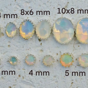 May include: Assortment of opal cabochons in various sizes, ranging from 3 mm to 10x8 mm. The cabochons are set in silver bezels with a scalloped edge.