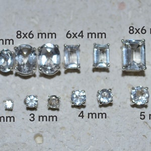 Könnte beinhalten: Eine Größenvergleichstabelle für klare Quarz-Edelsteine in verschiedenen Formen und Größen von 2 mm bis 8 mm. Die Tabelle enthält ovale, quadratische und runde Formen.