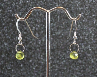 Peut inclure: Une paire de boucles d'oreilles en argent avec de petites gouttes de pierres précieuses vert clair.
