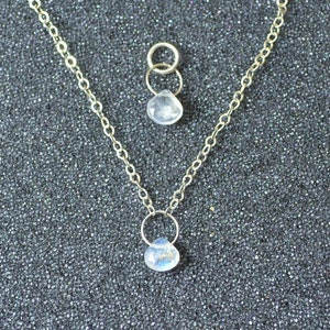 May include: A silver chain necklace with two teardrop-shaped moonstone pendants.
