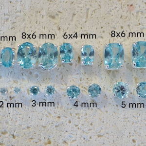May include: A size comparison of oval and round turquoise gemstones in silver settings. The stones range in size from 2 mm to 8 mm. The text on the image reads "6x4 mm", "8x6 mm", "6x4 mm", "8x6 mm", "2 mm", "3 mm", "4 mm", and "5 mm".