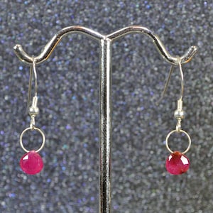 May include: A pair of silver dangle earrings with pink gemstone drops.