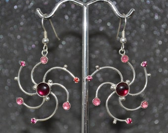 May include: Silver earrings with a spiral design and pink and red gemstones.