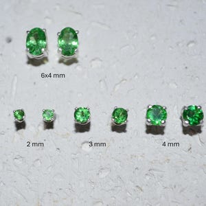 May include: A collection of green gemstone stud earrings in various sizes. The earrings are set in silver and include oval and round cuts. Sizes range from 2 mm to 6x4 mm.