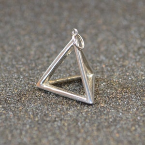 Puede incluir: Un dije de plata en forma de pir&aacute;mide con un bucle en la parte superior para sujetarlo a un collar o pulsera.