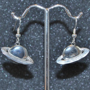 Hollow Cast Dimensional Ringed Planet Dangle Earrings. Silver iconic Saturn planetary theme, non-plated, nickel free and hypoallergenic.