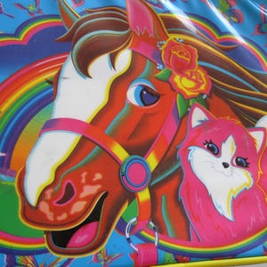 Puede incluir: Una ilustración colorida de un caballo y un gato con un fondo de arcoíris. El caballo tiene una crin marrón y una brida rosa. El gato es rosa con pelaje blanco. El fondo es azul con un arcoíris.
