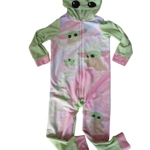 May include: Green and pink hooded pajamas with a character from the Star Wars franchise. The pajamas have the words "Play", "Snack", "Sleep", and "Repeat" printed on them.