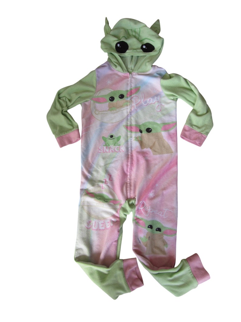 May include: Green and pink hooded pajamas with a character from the Star Wars franchise. The pajamas have the words "Play", "Snack", "Sleep", and "Repeat" printed on them.