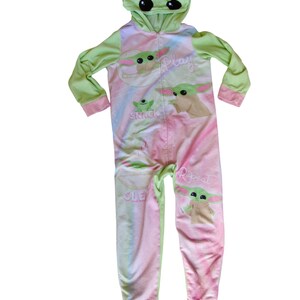 May include: Green and pink hooded onesie with a character from the Star Wars franchise. The onesie has the words "Play", "Snack", "Sleep", and "Repeat" printed on it.