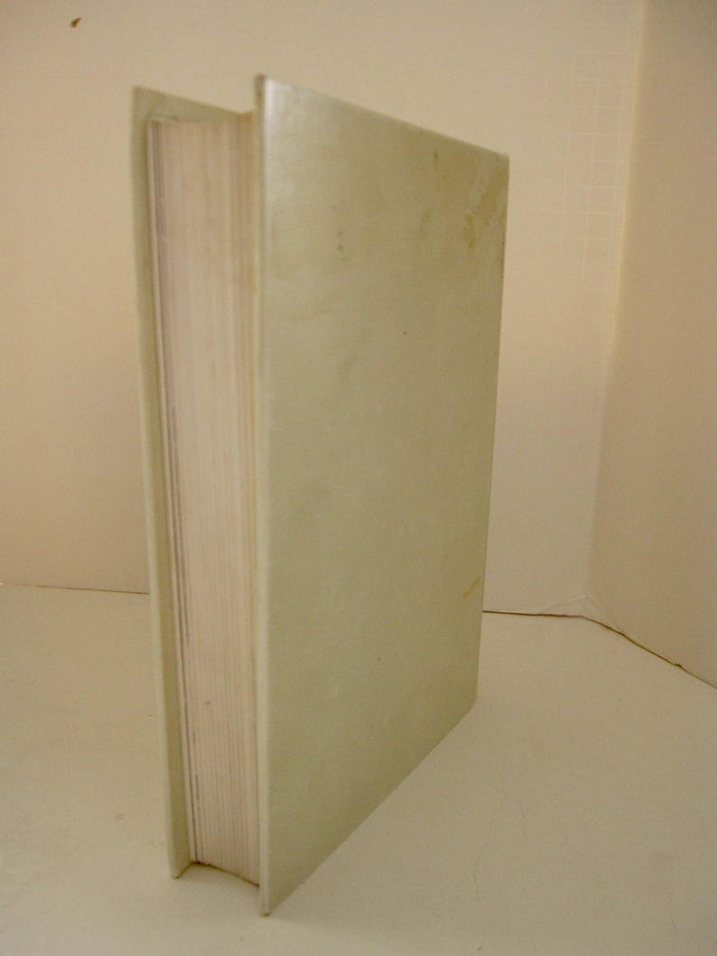 Peut inclure: Un livre &agrave; couverture rigide avec une couverture vert clair. Les pages du livre sont visibles sur le c&ocirc;t&eacute; gauche, et le dos est &agrave; gauche. La couverture a un aspect l&eacute;g&egrave;rement textur&eacute;.