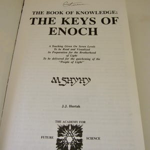 Peut inclure: Livre ouvert intitul&eacute; "THE BOOK OF KNOWLEDGE: THE KEYS OF ENOCH" avec du texte sur l'enseignement et la fraternit&eacute;. Auteur J.J. Hurtak. Comporte le logo de l'Acad&eacute;mie pour la Science Future. Pages blanches avec texte noir.